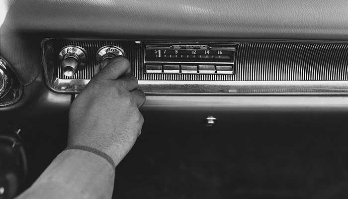 A man turns on a fifties style car radio