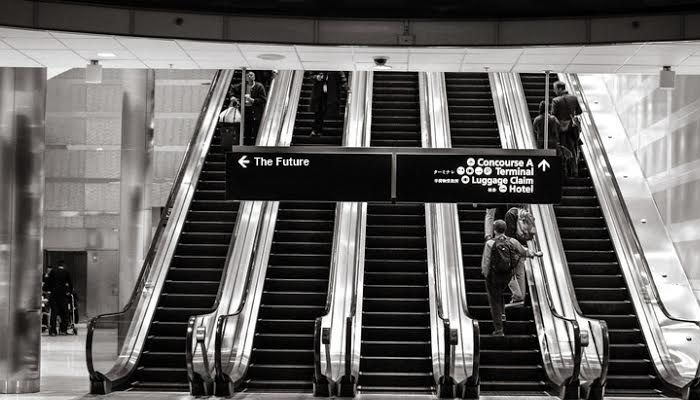 a set of escalators in an airport photographed in black and white