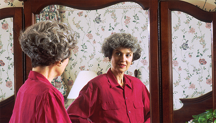 Woman thinking of Christ while looking in the mirror
