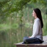 Woman meditates on dock