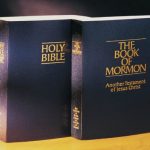 Holy Bible and Book of Mormon standing together on a table