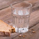 Glass of water and broken bread