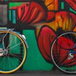 Bikes in front of a wall of graffiti.