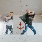 two kids pillow fighting with each other during covid-19